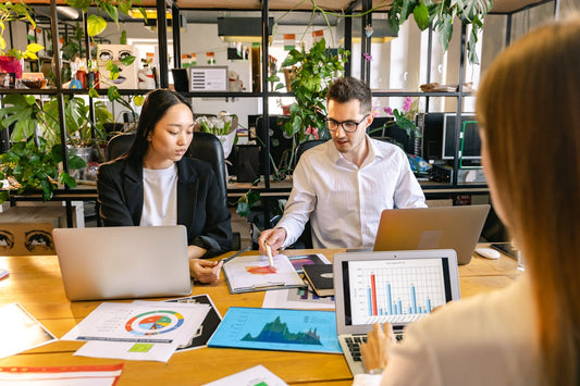 Deux femmes et un homme assis dans un bureau de travail. 