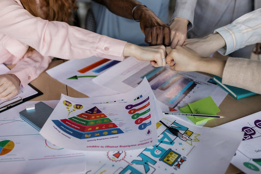 Cohésion d’équipe montré à travers des mains en forme de poings au-dessus d’une table de travail. 